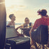 Friends at a beach table with a Dometic CFX3 cooler beside them