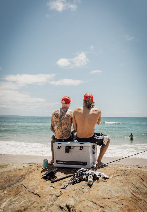 Two men fishing from a beach with a Dometic Cool-Ice icebox