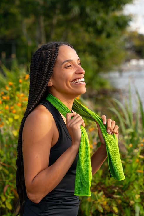 Woman wearing a Coghlan's green cooling towel around her neck outdoors