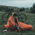 Cyclist resting in the Lifesystems Survival Bag on a hillside