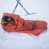 Hiker lying in the Lifesystems Survival Bag in snow