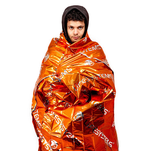 Person wrapped in the Lifesystems Thermal Bag, orange outer and silver inner