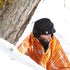 Person sitting in the Lifesystems Thermal Bag in snow