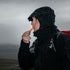 Hiker blowing the Lifesystems Echo Whistle on a misty hill