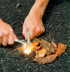 Camper lighting kindling with a Coghlan's magnesium fire starter