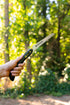 Camper holding a Coghlan's sierra saw in a forest