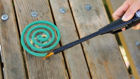 Coghlan's mosquito coil burning on a wooden deck outdoors