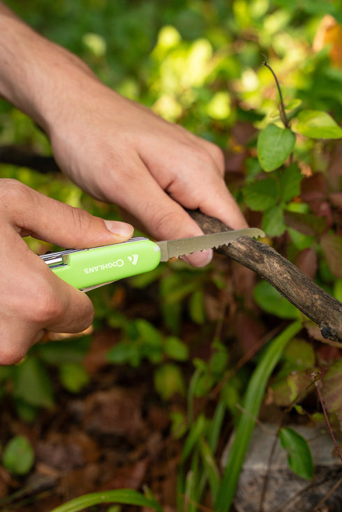 Camper using a Coghlan's 11 function camp knife outdoors