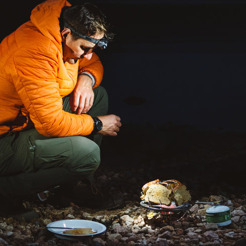 Camper using the Highlander 4 Slice Camping Toaster on a gas stove at night