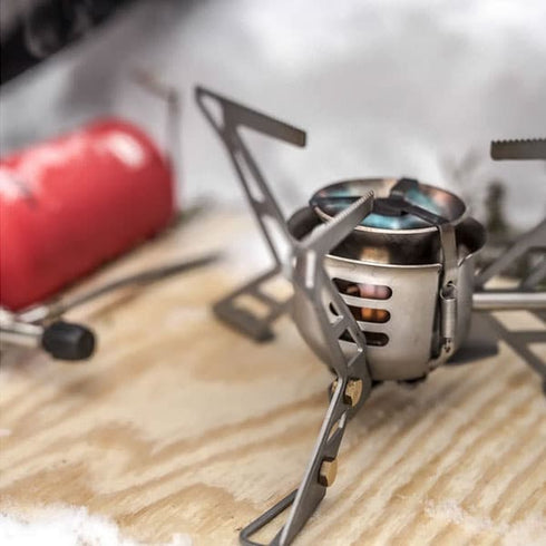 Primus OmniFuel stove burning on a rock outdoors, lifestyle