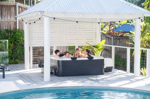 MSpa Oslo Aero Plus square hot tub in use under a garden gazebo beside a pool