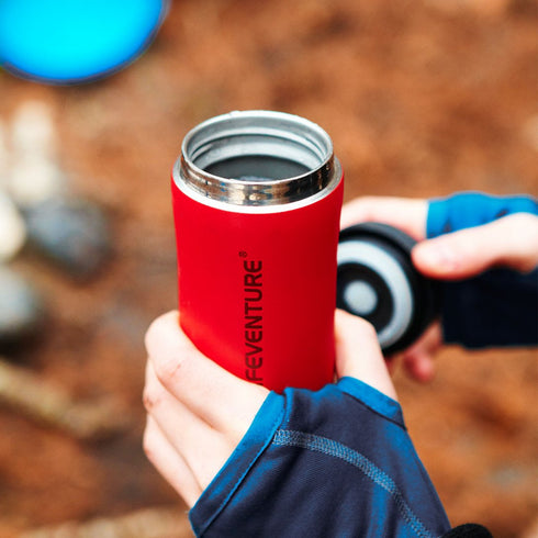 Hand holding a Matt Red Lifeventure Thermal Mug outdoors