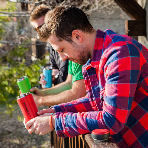 Camper drinking from a red Lifeventure Thermal Mug